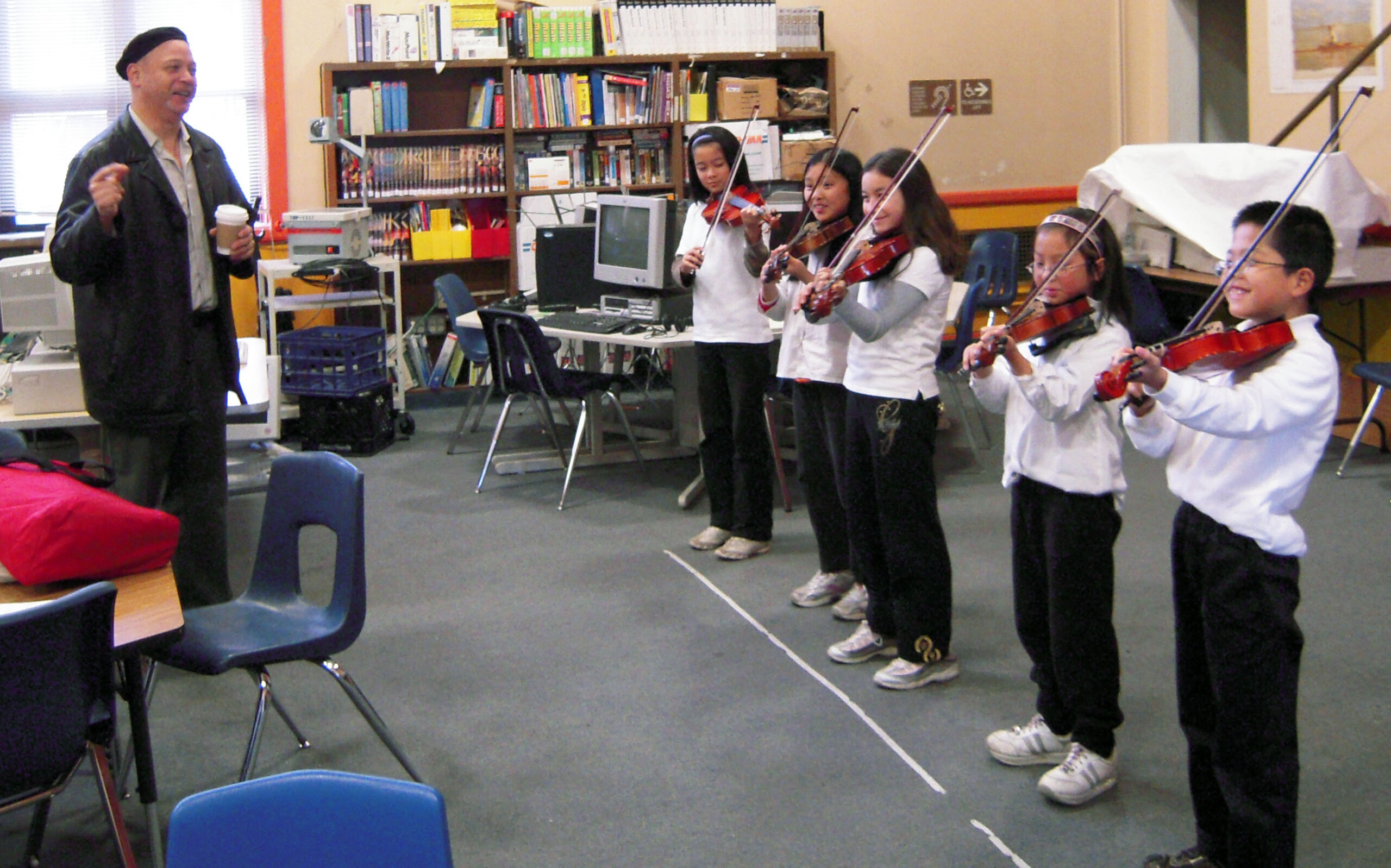 Dr. John Calloway teaching students violin at E. R. Taylor elementary school